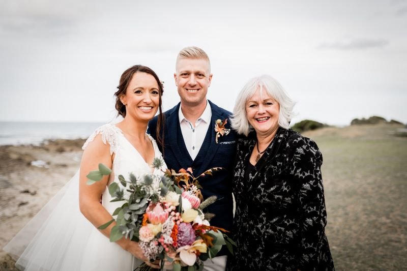 Wedding celebrant on beach with wedding couple